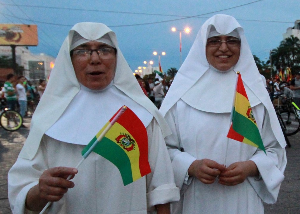 Religiosas marcham pelas ruas de Santa Cruz de La Sierra com bandeiras da Bolívia no domingo (10) — Foto: Daniel Walker/AFP