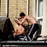 Foto: (Jovem corta o cabelo de outro homem sobre a laje de um salão de beleza em Oxford, na Inglaterra / Eddie Keogh/Reuters)