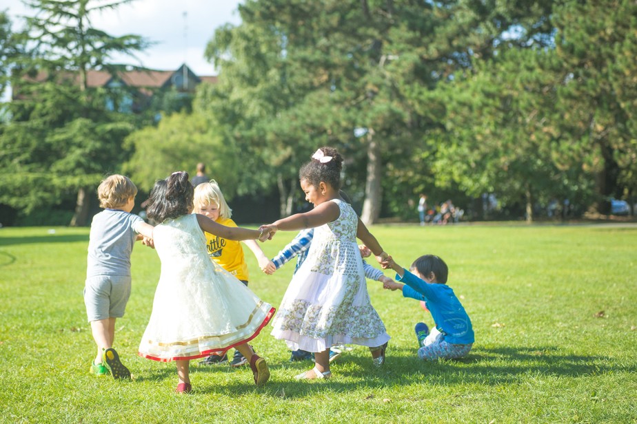 Crianças brincando de ciranda no parque. Foto: Unsplash
