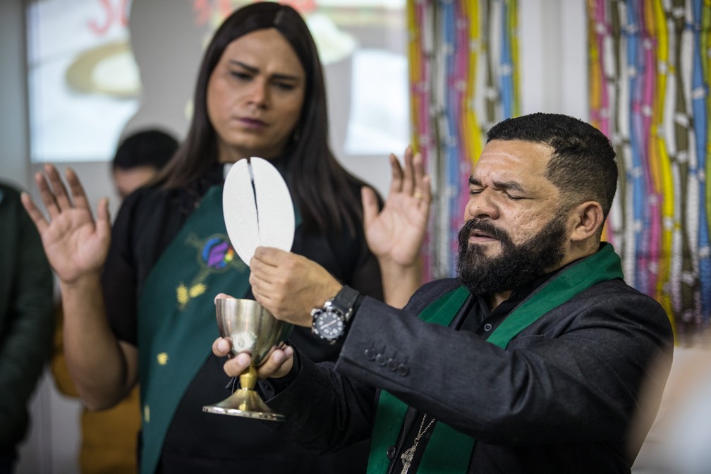 O reverendo Cristiano Valério abençoa o pão e o vinho para celebração da ceia ao lado de Alexya Salvador durante culto em uma igreja inclusiva de São Paulo (Foto: Fábio Tito/G1)