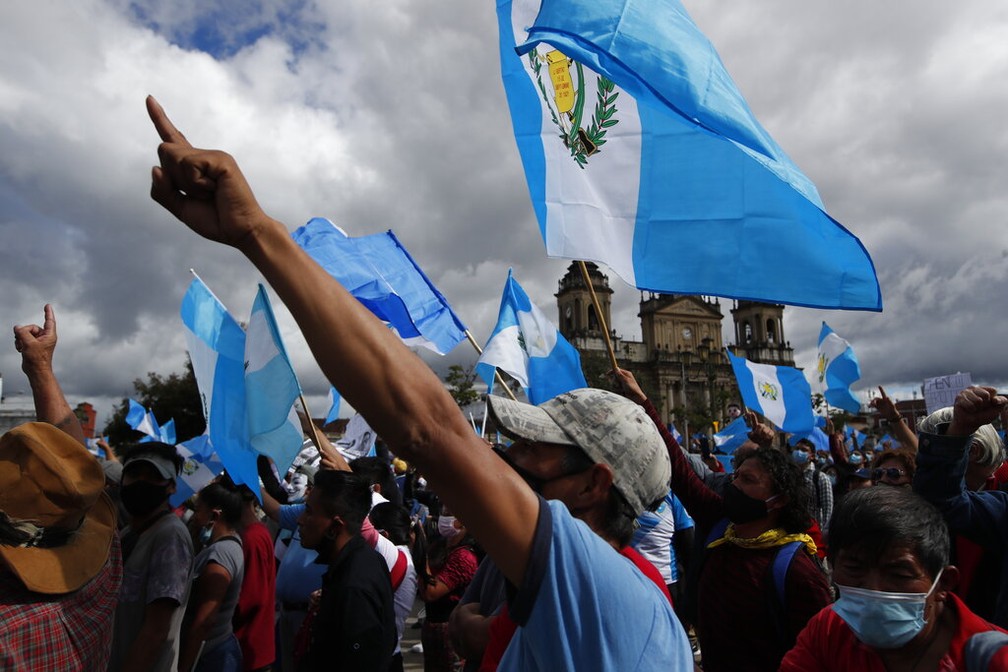 Com bandeiras da Guatemala, manifestantes pedem a saída do presidente Alejandro Giammattei neste sábado (21) — Foto: Moises Castillo/AP Photo