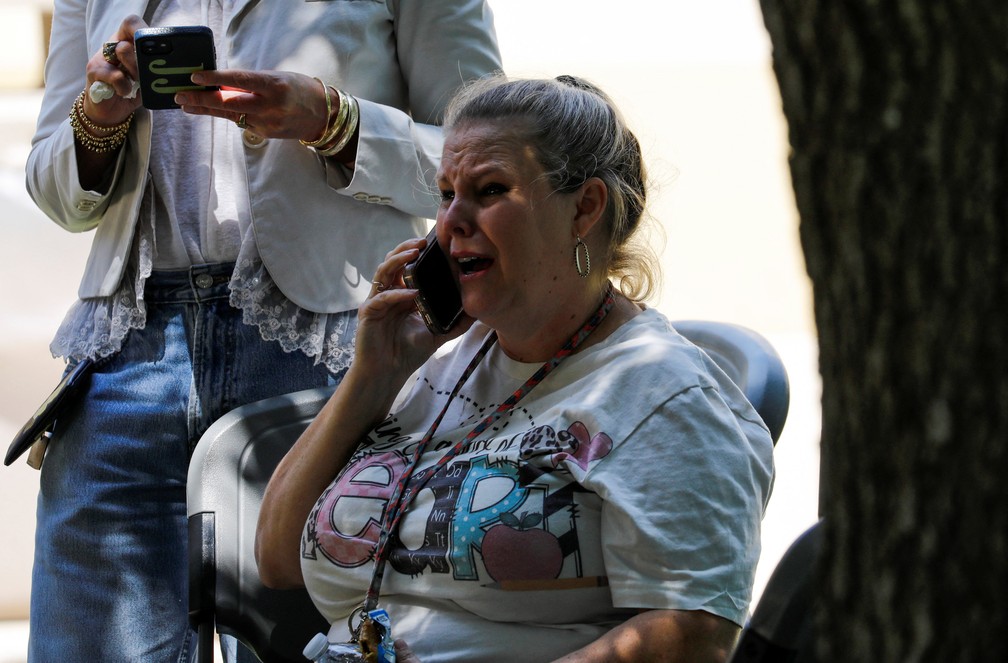 Mulher chora ao telefone após ataque em escola do Texas em 24 de maio de 2022 — Foto: Reuters