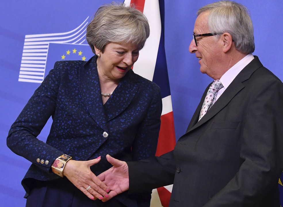 O presidente do Comissão Europeia, Jean-Claude Juncker, aperta a mão da primeira-ministra britânica, Theresa May, durante encontro em Bruxelas neste sábado (24)  — Foto: AP Photo/Geert Vanden Wijngaert