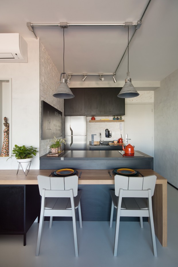 Apartamento de 39 m² com estilo industrial tem sala de estar na varanda (Foto: Divulgação)