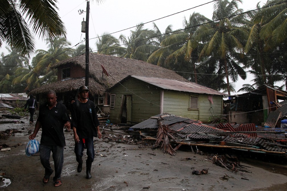 Homens atravessam uma casa destruída pela passagem do furacão Irma, em Nagua, República Dominicana (Foto: Ricardo Rojas/Reuters)