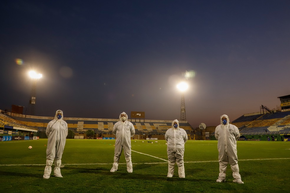 Equipe médica que trabalhou no jogo Sportivo Luqueño 2 x 2 Olimpia, pelo Campeonato Paraguaio: Conmebol promete controle rígido contra o contágio do coronavírus — Foto: Nathalia Aguilar/EFE