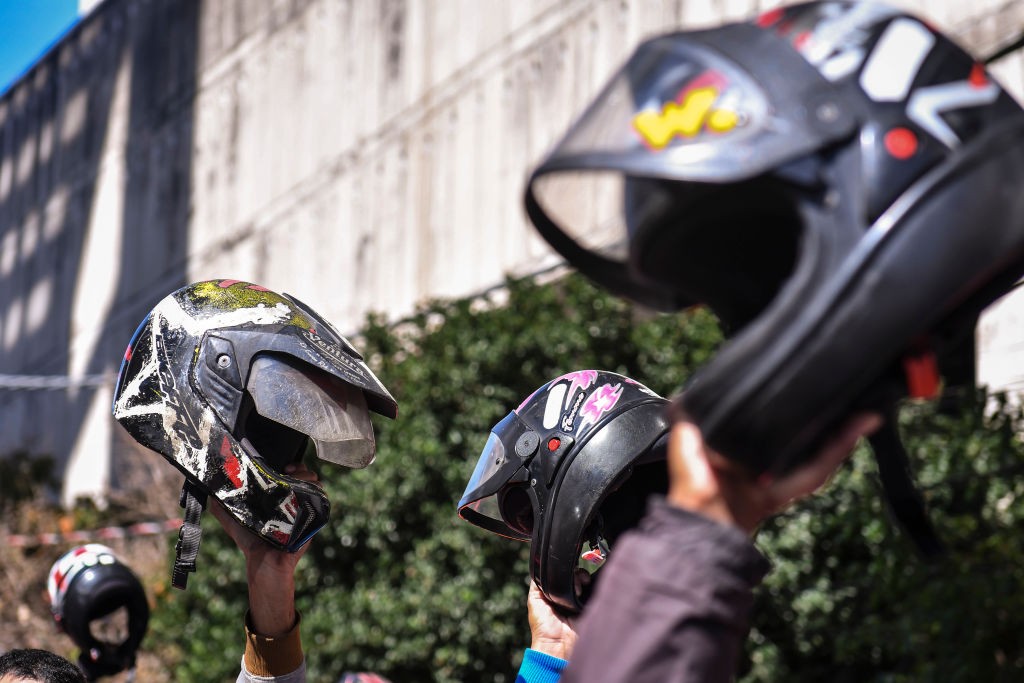 BELO HORIZONTE, BRAZIL - JULY 01: Delivery app workers raise their motorcycle helmets in front of the department of labor as they take part in a protest to demand better working conditions on July 1, 2020 in Belo Horizonte, Brazil. The demonstration takes (Foto: Getty Images)