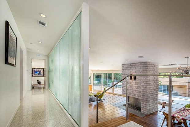 O piso de terrazzo no hall de entrada faz par com a lareira com tijolos cinza da sala de estar (Foto: Dirt / Reprodução)