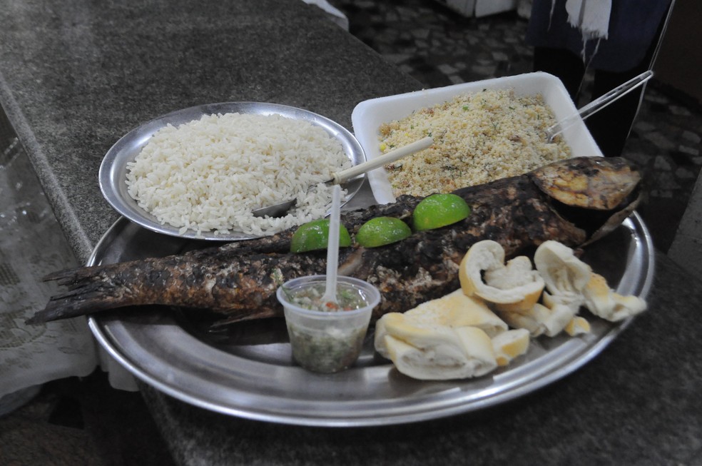 Em Guarujá, tainha recheada e assada na brasa acompanha arroz, farofa e pão — Foto: Roberto Sander Jr. 