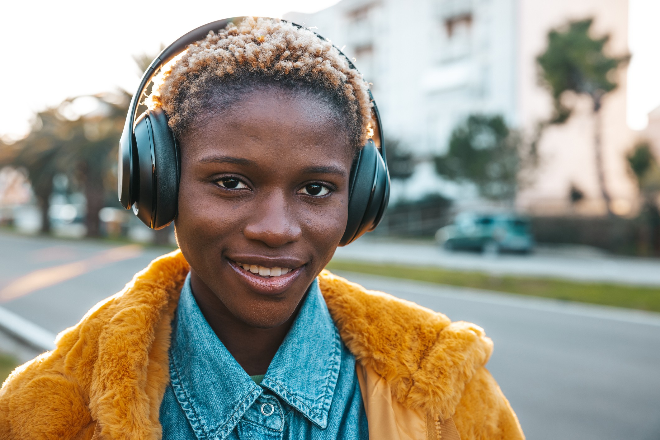 Teenage girl listening to music in the street using wireless headphones. (Foto: Getty Images)