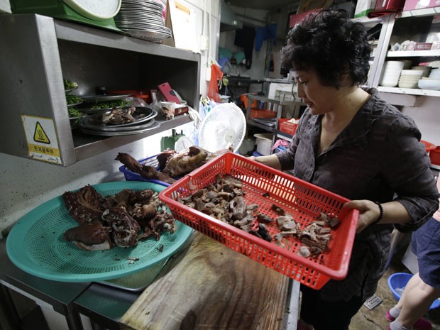 A chef Oh Keum-il, dona do restaurante Daegyo, mostra como cozinhar carne de cachorro; estabelecimento que existe desde a década de 1980 vai fechar (Foto: Lee Jin-man/AP)
