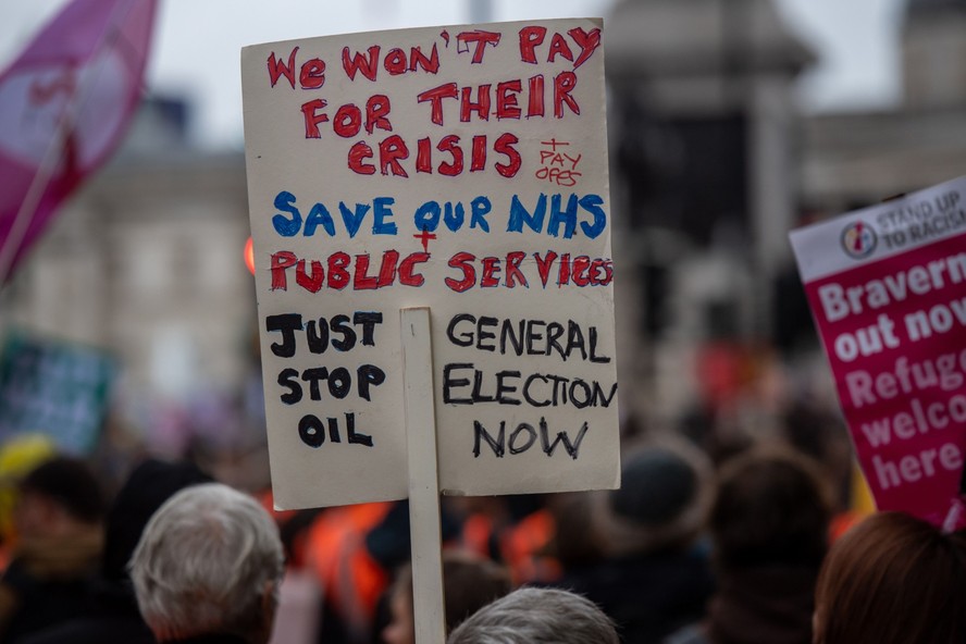 Durante um comício contra políticas de austeridade em Londres no último sábado, manifestante pede 'Salvem o nosso NHS'