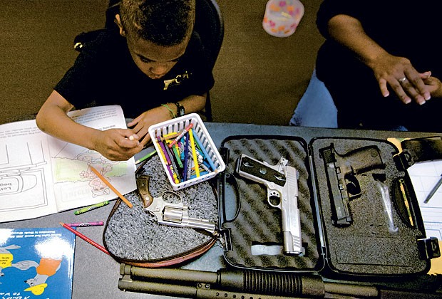 ESCOLINHA DE TIRO Alex, 7 anos, aprendeu a atirar com os pais, donos de uma escola de tiro voltada a crianças e adultos (Foto: Alex Quesada)