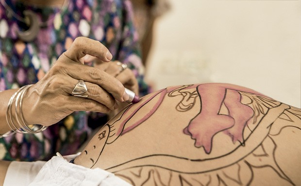 As mãos da parteira Naolí Vinaver finalizando com batom o desenho de como o bebê está dentro da barriga da mãe. (Foto: Naolí Vinaver (arquivo pessoal))