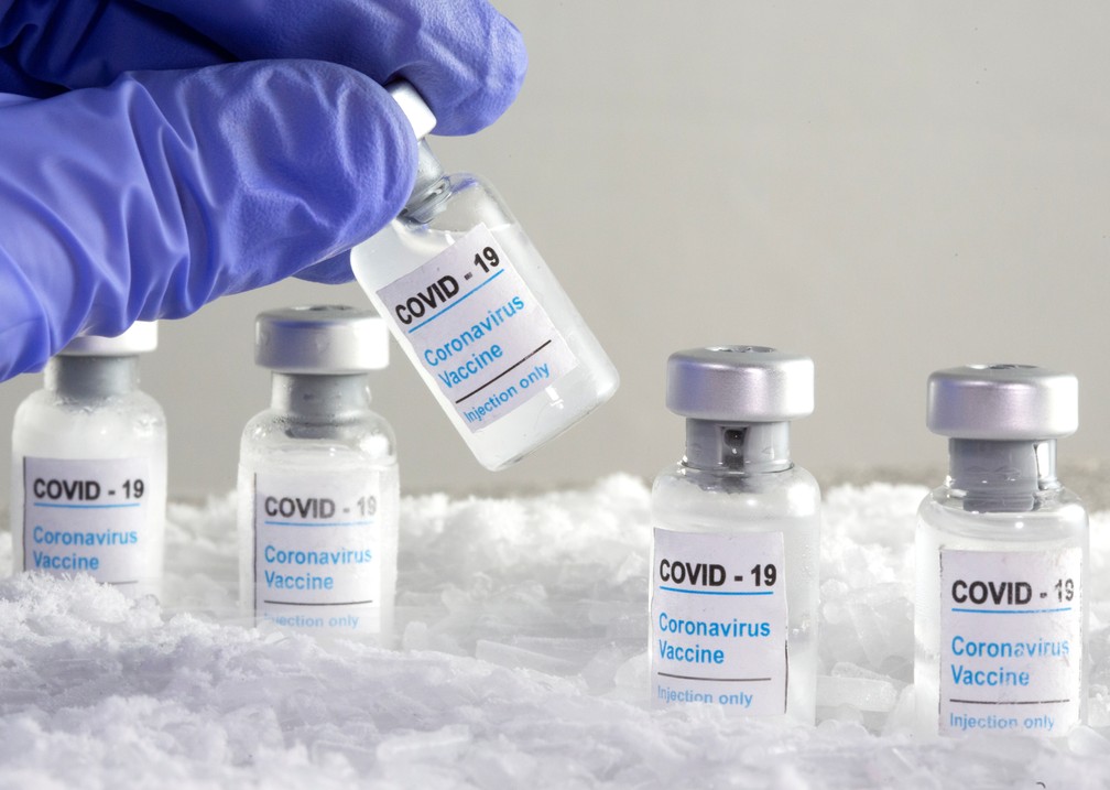 Mulher segura frasco rotulado como de vacina contra Covid-19 em foto de ilustração. — Foto: REUTERS/Dado Ruvic