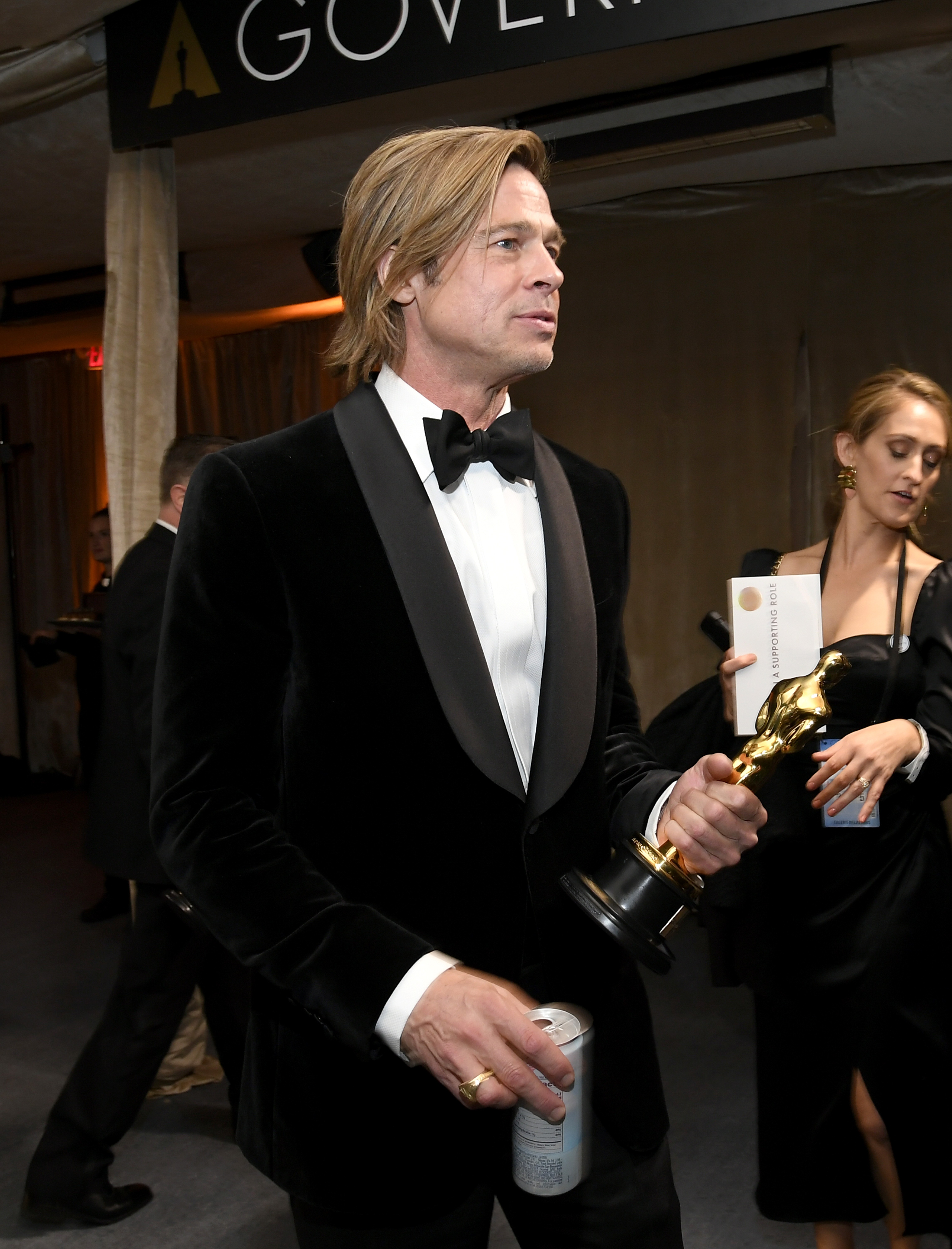 O ator Brad Pitt chegando à festa pós-Oscar organizada pela Academia de Artes e Ciências Cinematográficas de Hollywood com o troféu vencido por ele em uma das mãos e uma latinha de cerveja na outra (Foto: Getty Images)