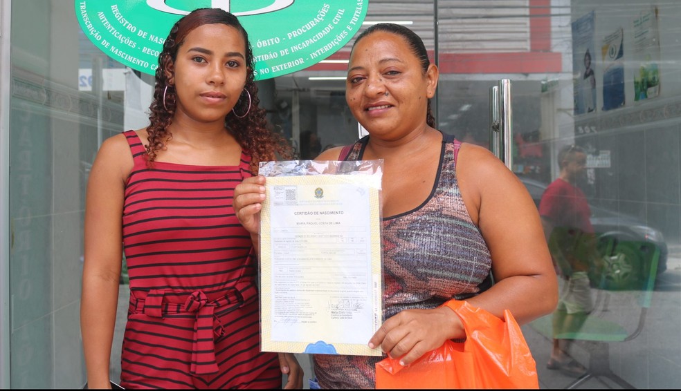 Raquel, à esquerda, obteve certidão de nascimento com sobrenome e filiação após 18 anos de vida. — Foto: Defensoria Pública/Divulgação 