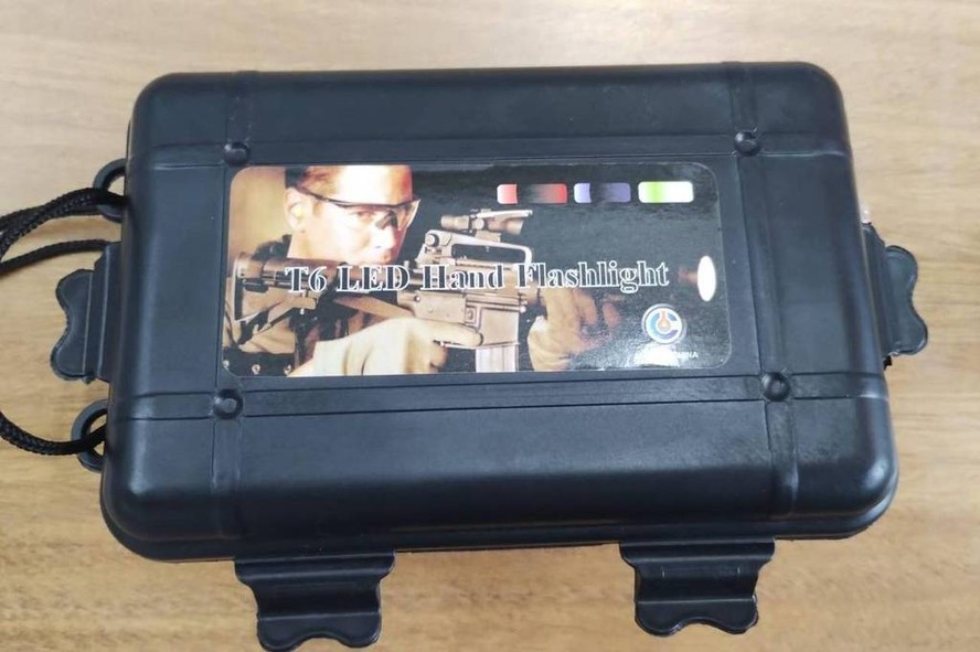 Imagem de fuzil aparece nas caixas em que foram entregues lanternas de led às escolas municipais