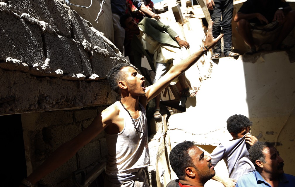 Iemenitas se protegem de poeira depois de bombardeios liderados pelos sauditas, na capital Sanaa, na quinta (16) â€” Foto: Mohammed HUWAIS/AFP