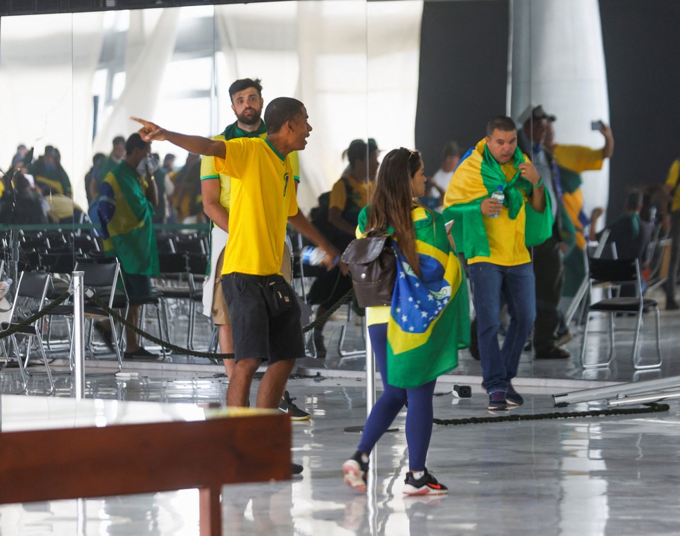 Marco Túlio Rios, no centro da foto, com blusa branca na cintura, foi flagrado no Congresso em Brasília no domingo (8) — Foto: Adriano Machado/Reuters — Foto: Adriano Machado / Reuters