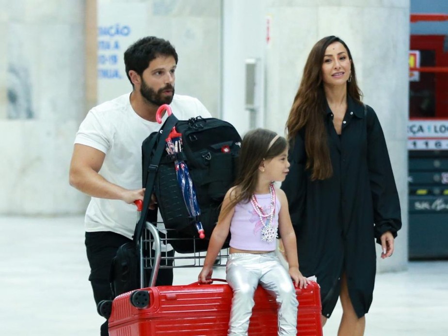 Sabrina Sato e Duda Nagle carregam Zoe em cima de malas em aeroporto no Rio