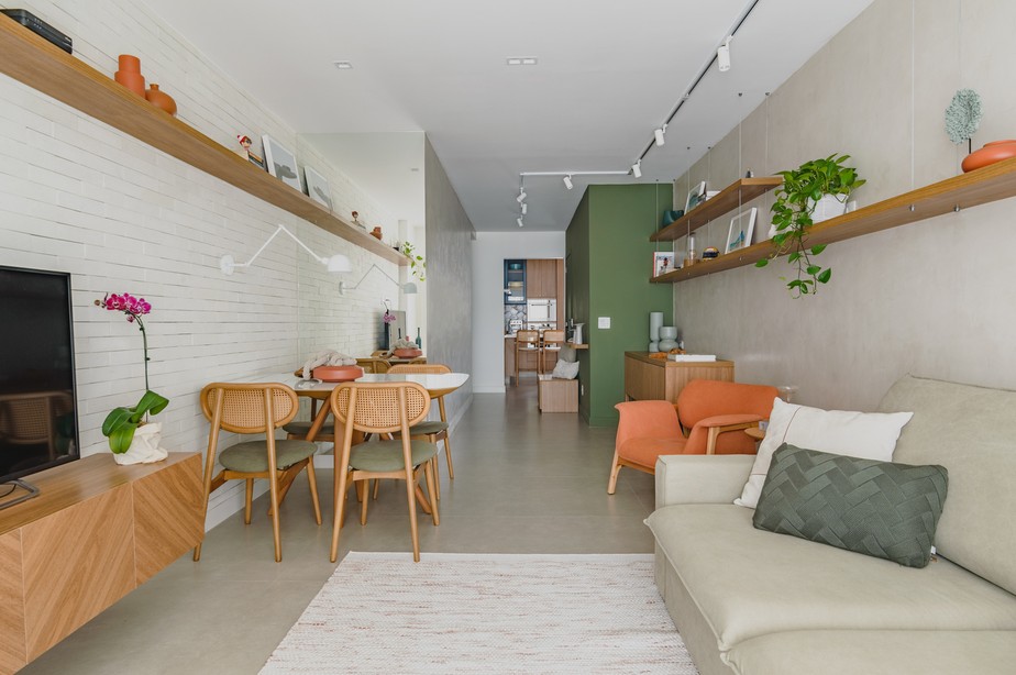 LIVING | Mesmo com a base neutra, pontos focais de cor aparecem na decoração. A parede verde prende a atenção dos visitantes. Cadeiras são da Relicário Urbano