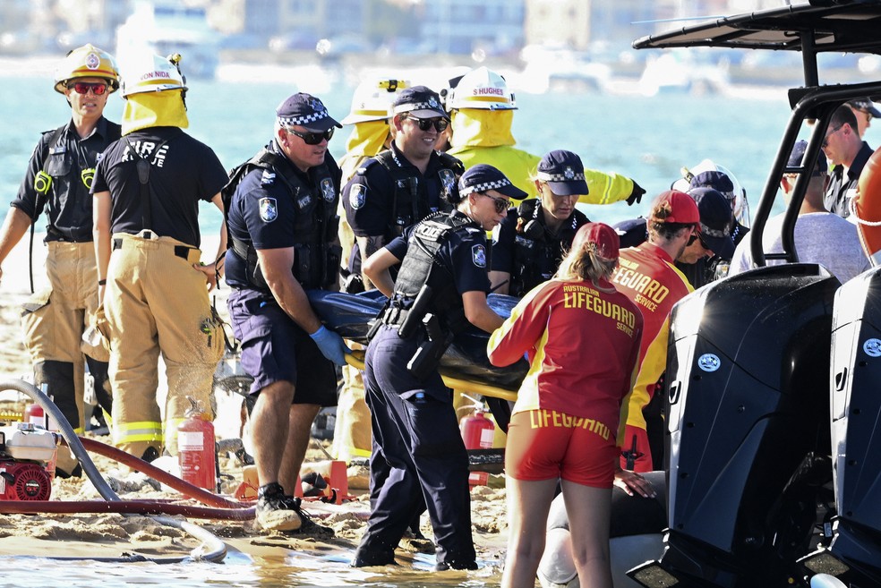 Equipe de resgate remove corpo da cena de colisão entre dois helicópteros — Foto: Dave Hunt/AAP Image via AP