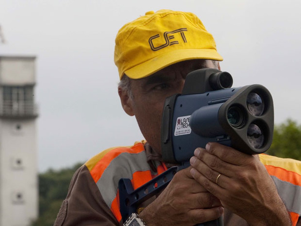 Agente da Companhia de Engenharia de Tráfego (CET)  com um radar pistola observa motoristas sobre pontes de São Paulo (Foto: Apu Gomes/Folhapress)