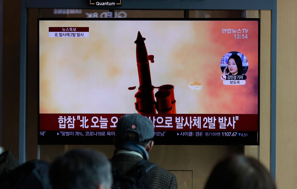 Pessoas assistem na Coreia do Sul um programa que fala sobre disparo de projeteis feitos pela Coreia do Norte nesta segunda-feira (2)   — Foto: Lee Jin-man/AP 