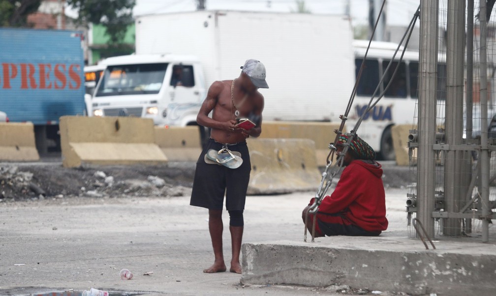 Homem segura vários celulares em ponto de uso de crack na Avenida Brasil (Foto: Marcos Serra Lima/G1)