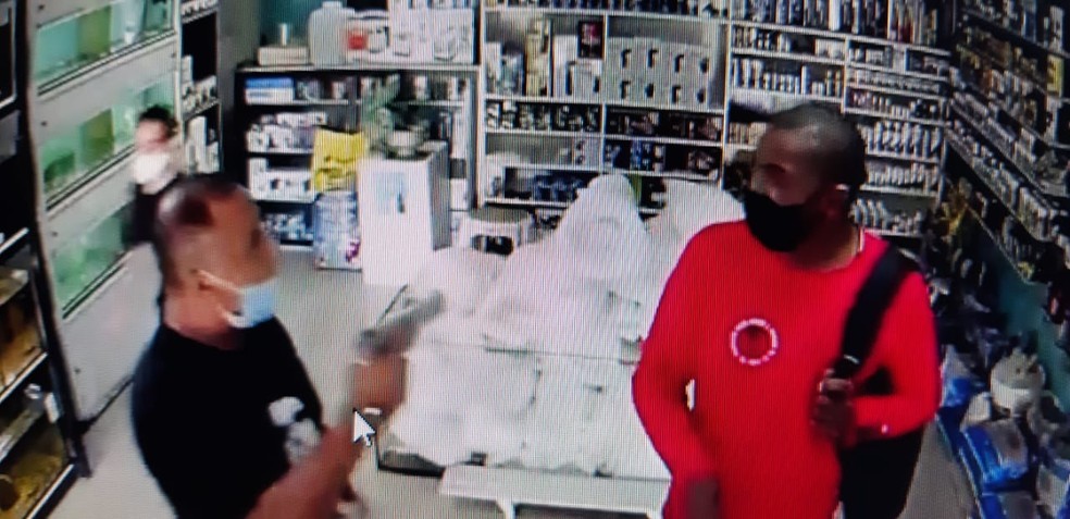 Bombeiro do DF, de camiseta preta, aponta arma para jovem que disse o ter denunciado por assédio, no Metrô do DF — Foto: Reprodução