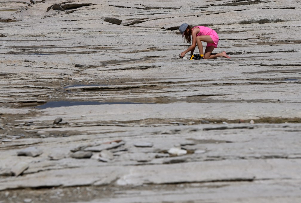 Leito rochoso do lago Garda aparece com a seca e forma uma praia em Sirmione, na Itália — Foto: REUTERS/Flavio Lo Scalzo