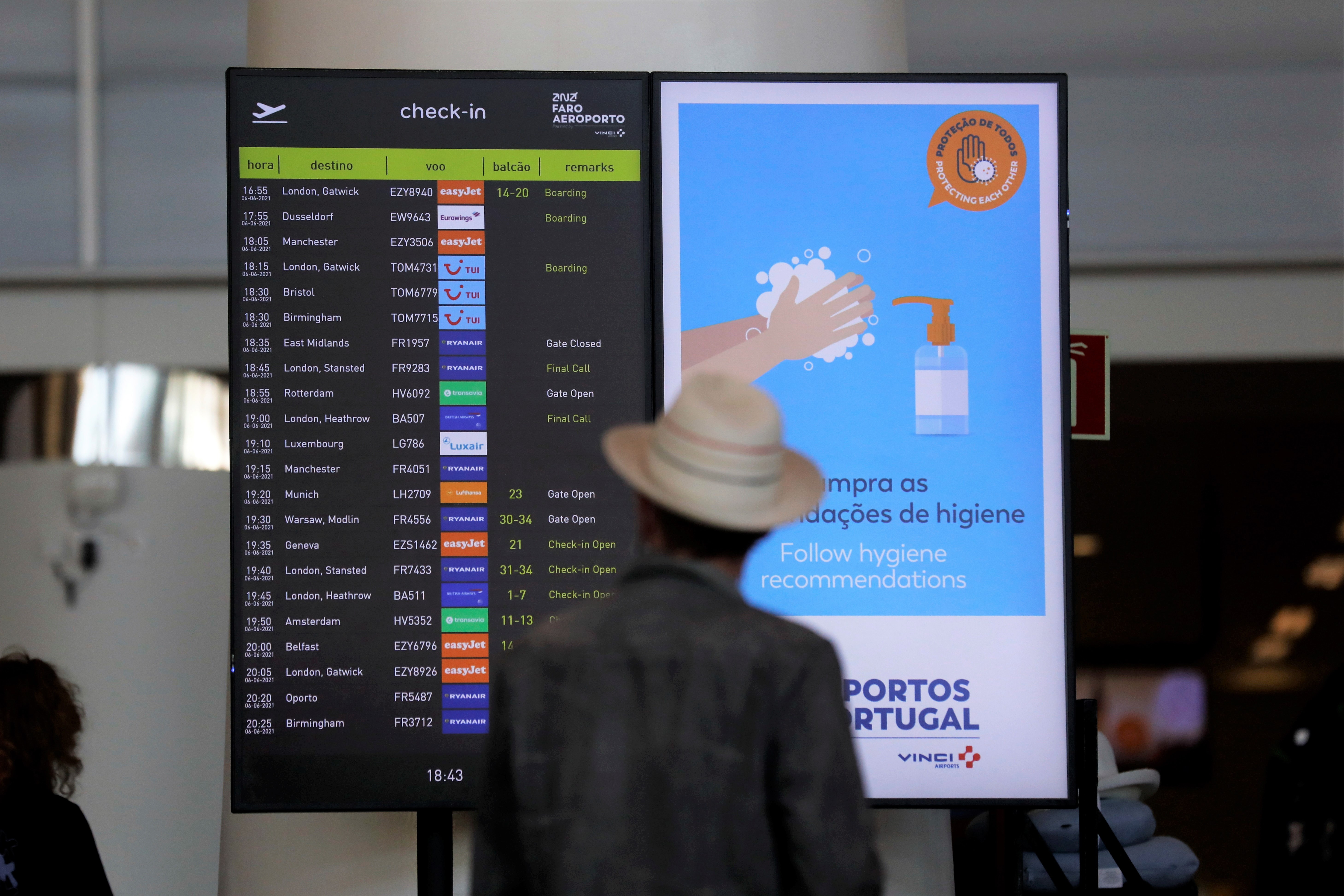 Passageiro confere informações de voos no aeroporto de Faro, em Portugal