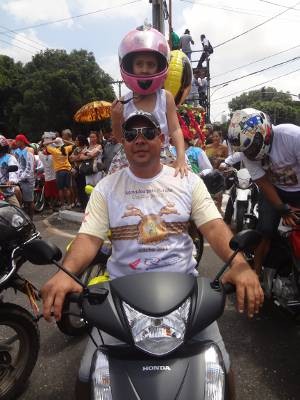 Devoto aproveitou que a procissão coincidiu no Dia das Crianças para levar a filha de 6 anos.  (Foto: Thais Rezende/ G1)
