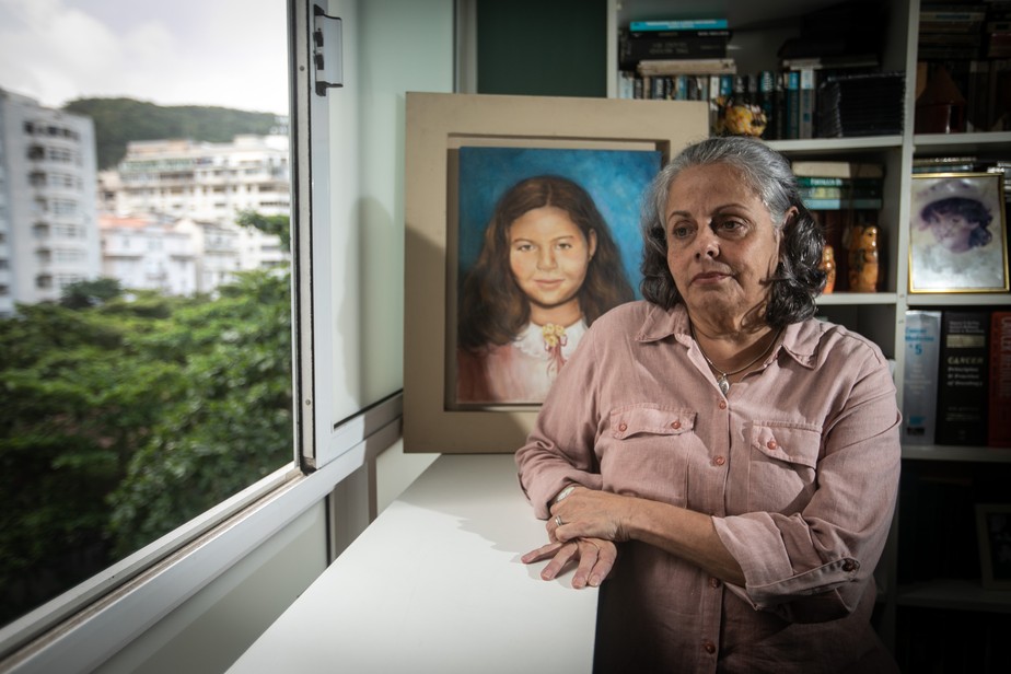 A médica Bárbara de Alencar Leon Martins diante do quadro com a imagem da filha