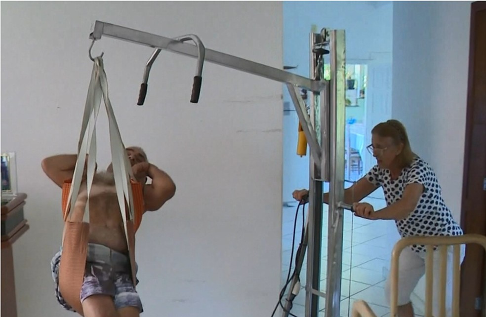 Dona Ãurea, mÃ£e de MÃ¡rcio AntÃ´nio, usa guindaste para transportar filho â Foto: ReproduÃ§Ã£o/TV Gazeta