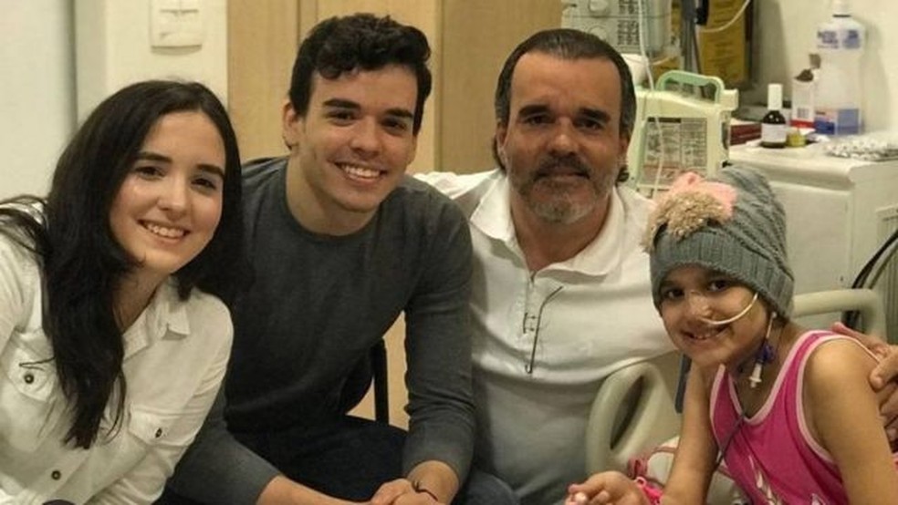 Anna Carolina, Pedro, Régis e Beatriz em hospital; família teve ao todo 11 diagnósticos de câncer.  — Foto: Arquivo pessoal via BBC