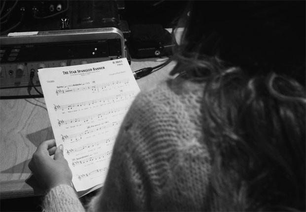 A cantora estudando a partitura do hino (Foto: Reprodução)