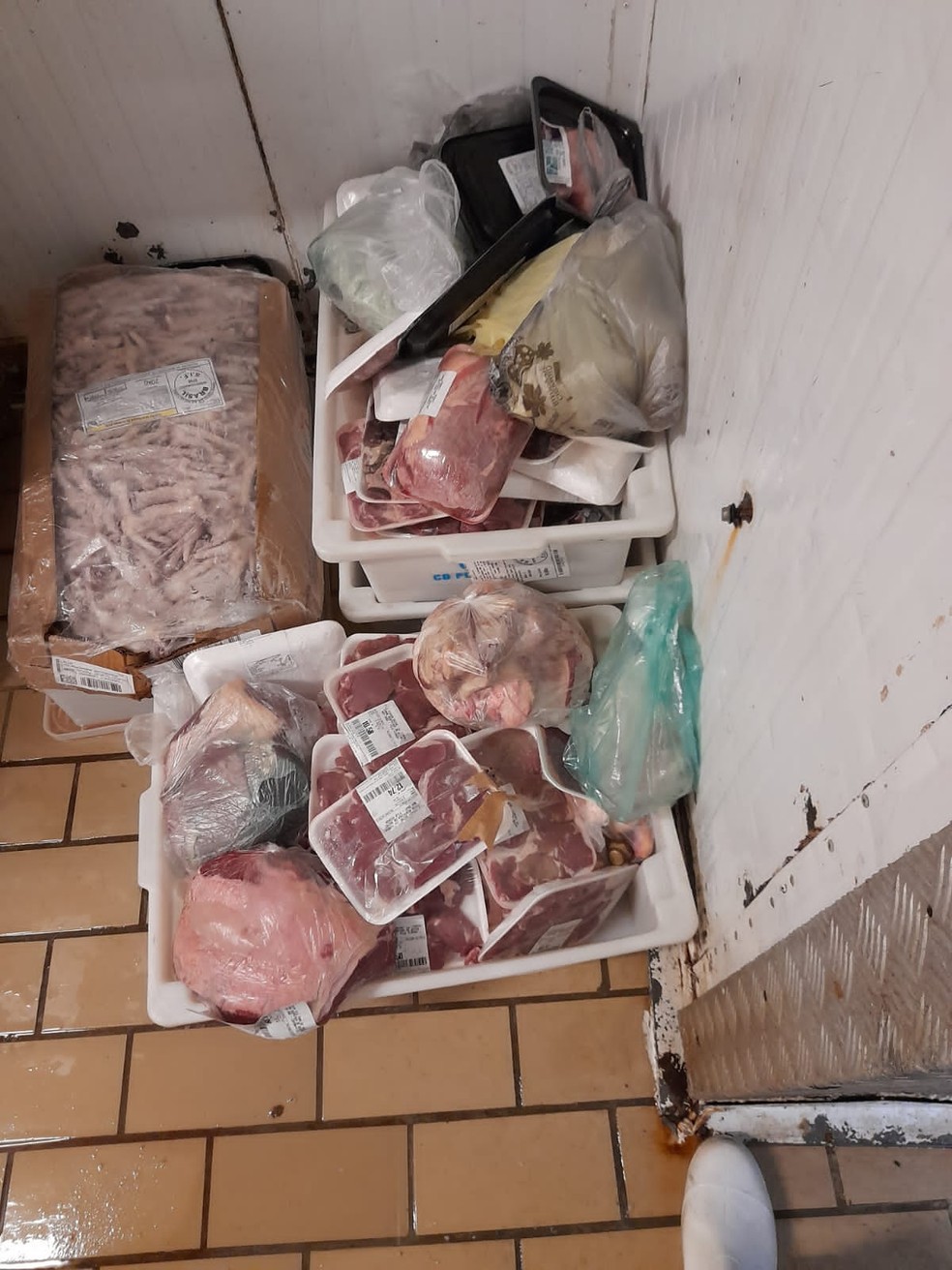 Carnes com data de validade vencidas empilhadas no chão do açougue: lavadas antes de serem recolocadas à venda — Foto: Arquivo pessoal