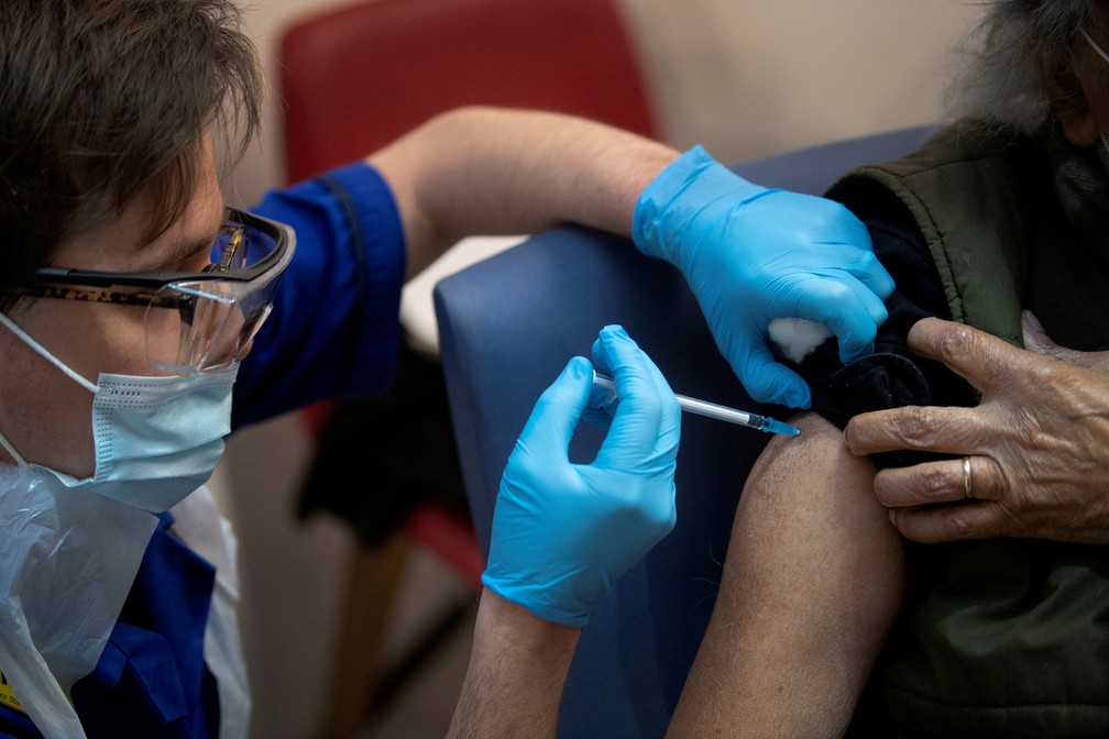 Um homem recebe a primeira de duas doses da vacina Pfizer/BioNTech contra a Covid-19, no Guy's Hospital em Londres em foto de 8 de dezembro de 2020 — Foto: Victoria Jones/Pool/Reuters/Arquivo