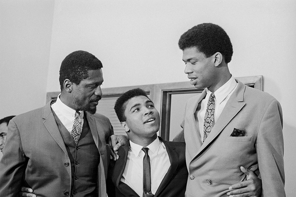 (Original Caption) Dwarfed by Bill Russell (left), six-foot, 11-inch player coach of the Boston Celtics, and 7-foot, 3-inch college star Lew Alcindor, Cassius Clay strains his neck as he talks with the two basketball giants. A group of the nation's top at (Foto: Bettmann Archive)