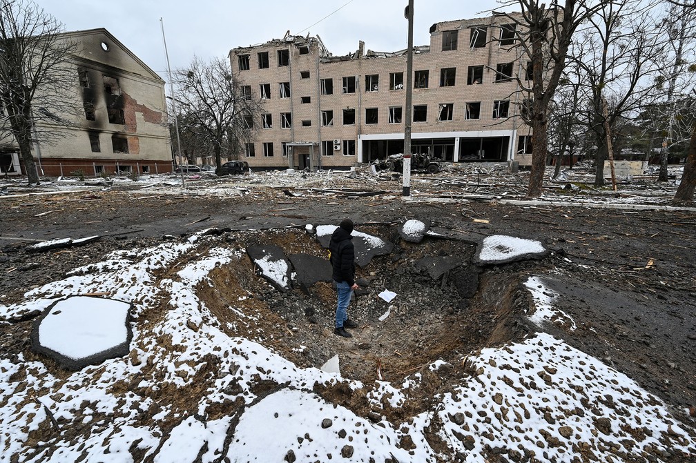 1º de março - Homem observa o interior de uma cratera resultado de bombardeio num posto militar de Brovary, perto d Kiev, na Ucrânia — Foto: Genya Savilov/AFP