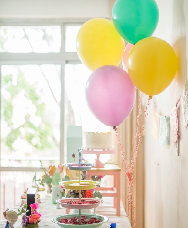 A mesa do bolo, de frente pra um janelão, ganhou destaque na festa. No cordão das bexigas, grelots cor-de-rosa (Foto: Carina Iwahashi/Editora Globo)