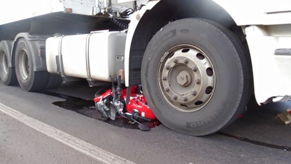 Moto parou embaixo de um dos rodados de caminhÃ£o em MaringÃ¡ â€” Foto: ReproduÃ§Ã£o/RPC