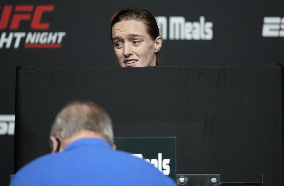 Aspen Ladd faz cara de dor enquanto se pesa nua por tr&aacute;s de um biombo na pesagem oficial do UFC &mdash; Foto: Jeff Bottari/Zuffa LLC