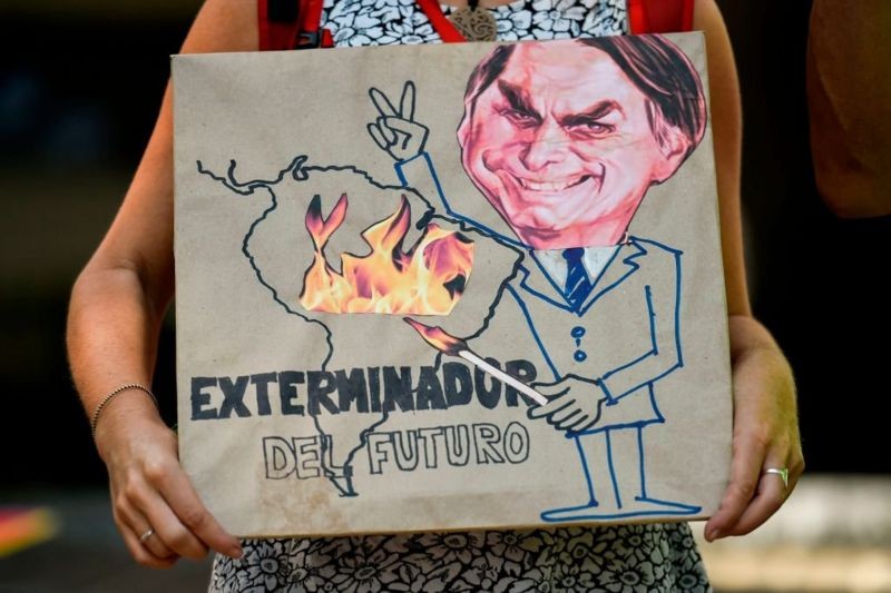 BBC 'Exterminador do futuro', diz cartaz que mostra Bolsonaro com um palito de fósforo, incendiando a Amazônia. Cali (Colômbia), agosto de 2019 (Foto: Getty Images via BBC)