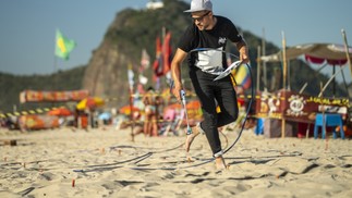O artista francês Saype durante produção da sua obra na praia de Copacabana — Foto: Saype