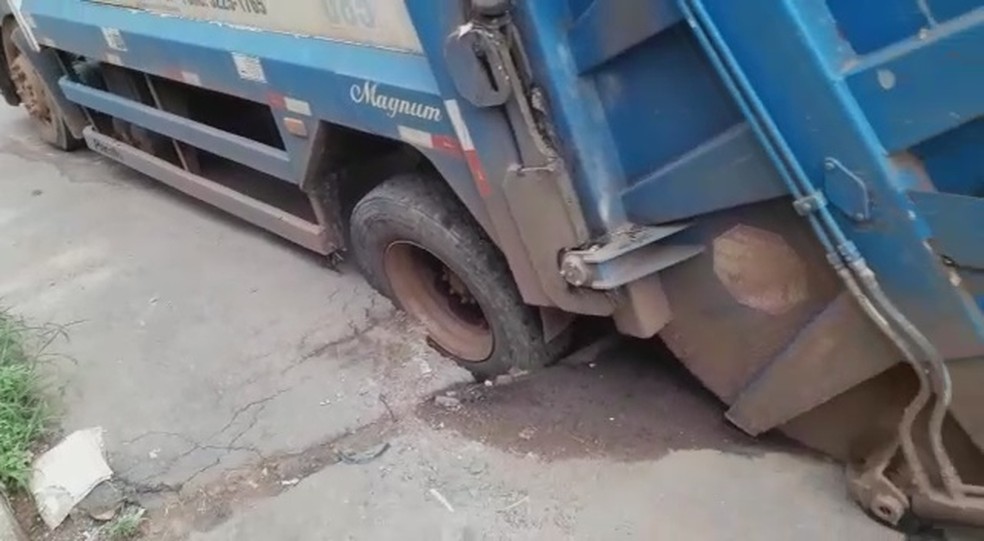 Caminhão de lixo precisou ser guinchado após cair em buraco (Foto: Reprodução)