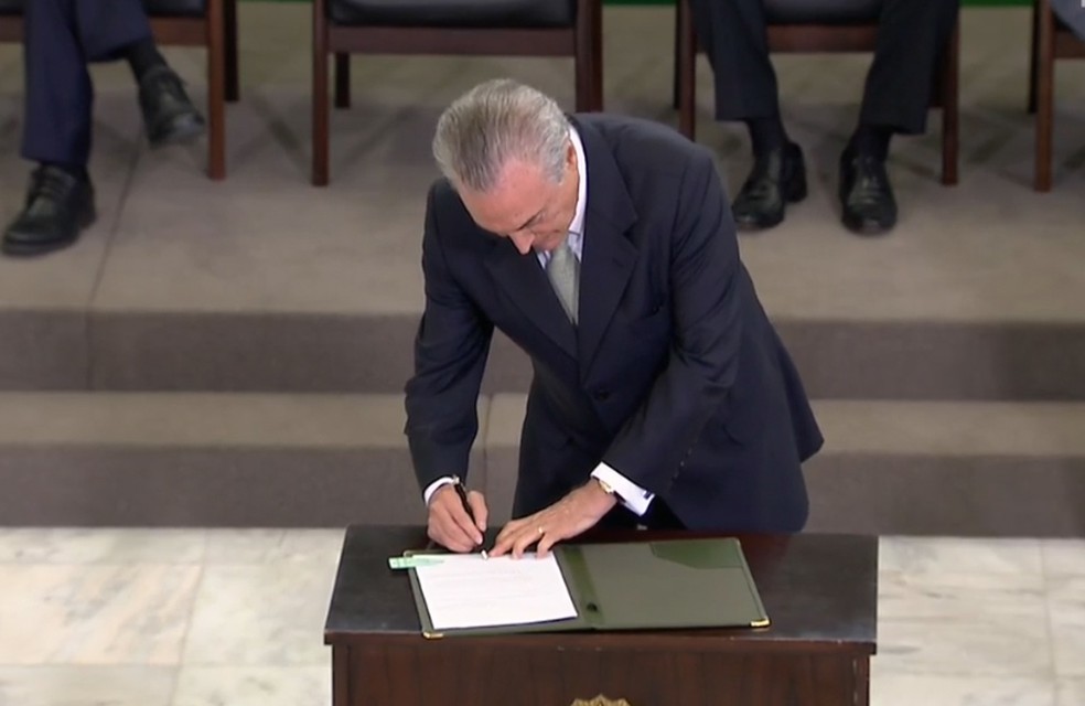 Temer assina documento durante cerimônia no Palácio do Planalto — Foto: Reprodução/NBR