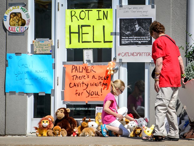 Cartaz com a mensagem ‘apodreça no inferno’ é visto na porta da clínica do dentista Walter Palmer, em Bloomington, Minnesota, na quarta (29) (Foto: Glen Stubbe/Star Tribune via AP)